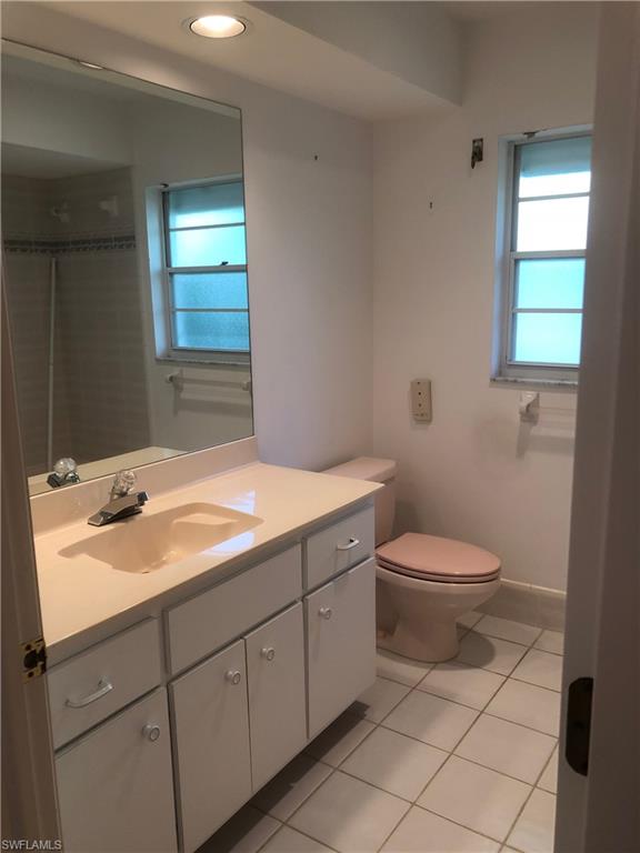 538 Roma Court Naples, FL 34110 - Photo 17 of 19 a bathroom with a toilet a sink and mirror