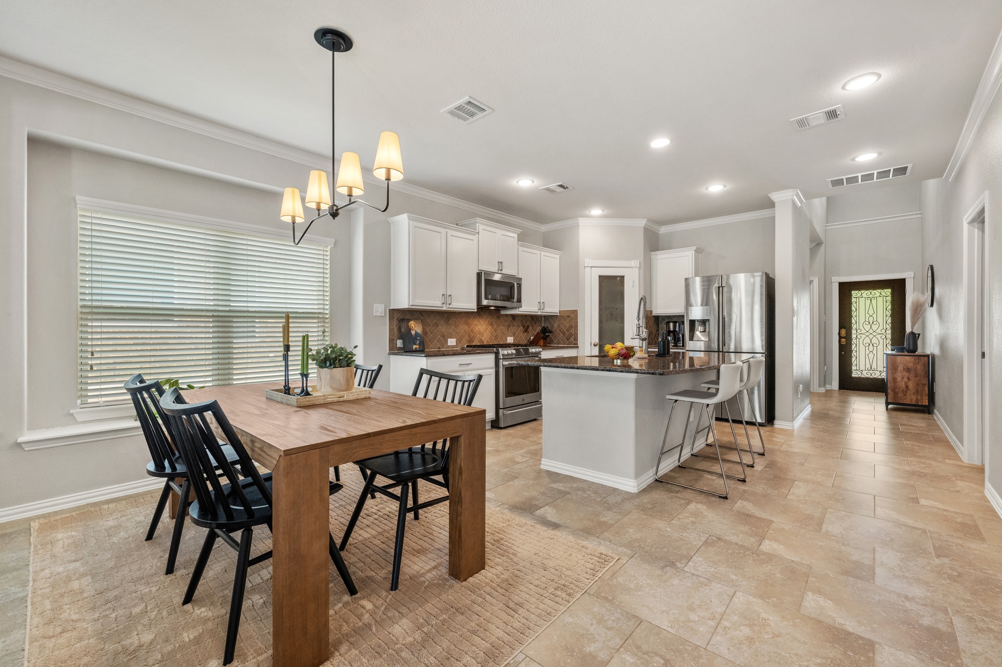 18312 Turning Stream Lane Pflugerville, TX 78660 - Photo 11 of 40 a view of a dining room and livingroom with furniture wooden floor and a chandelier