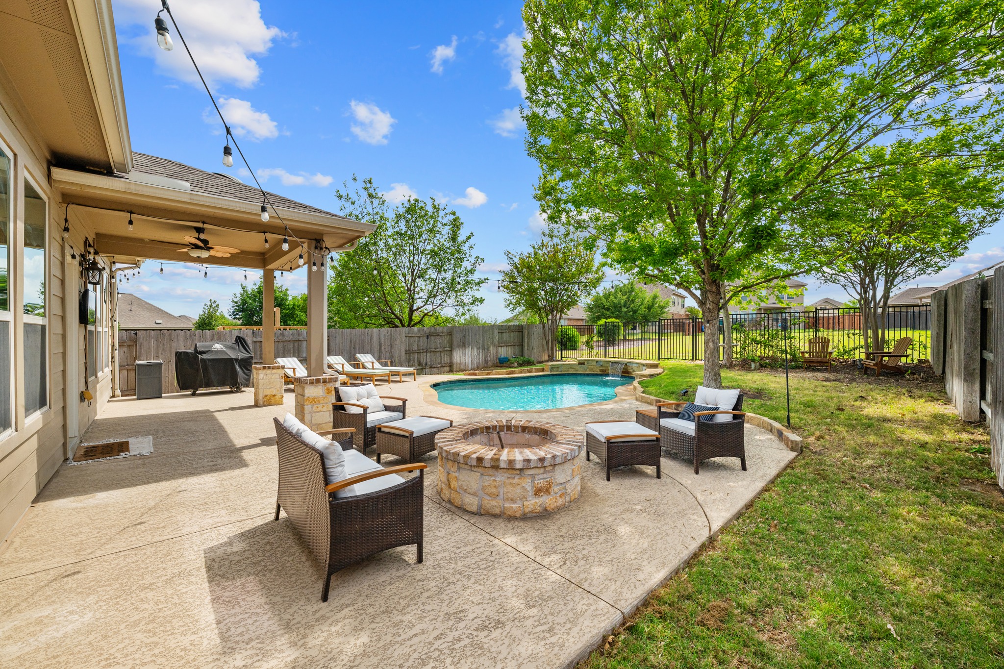 18312 Turning Stream Lane Pflugerville, TX 78660 - Photo 29 of 40 a view of a patio with couches and table and chairs with wooden fence and plants