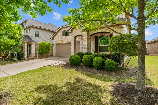a view of a house with a large tree and a yard