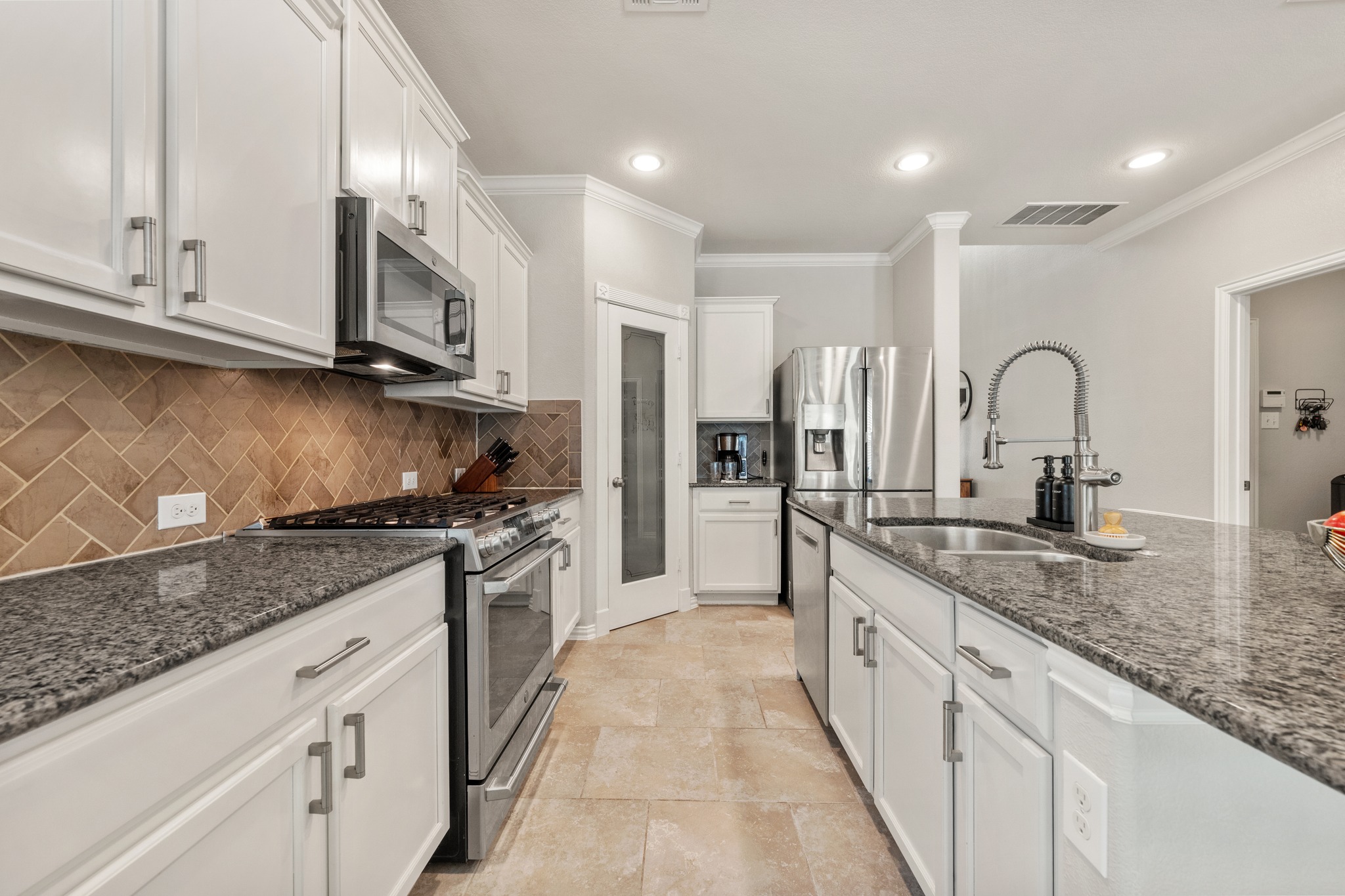18312 Turning Stream Lane Pflugerville, TX 78660 - Photo 10 of 40 a kitchen with stainless steel appliances granite countertop a stove a sink and a microwave