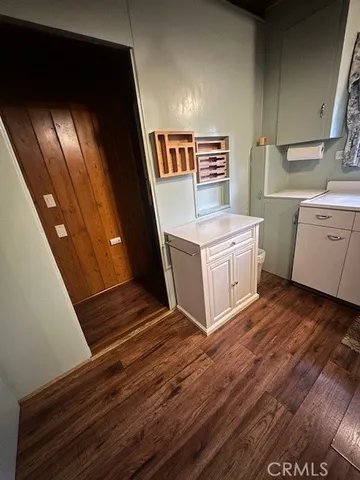 a view of a kitchen with cabinets and wooden floor
