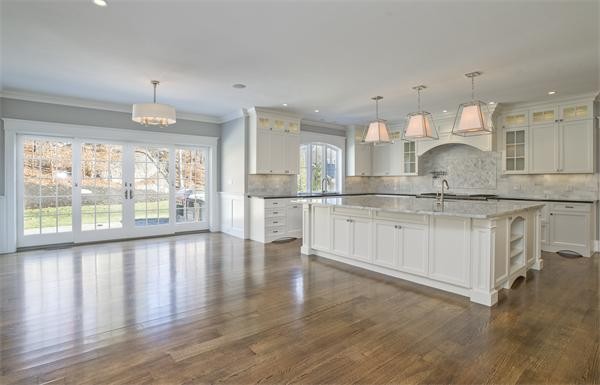 150 Princeton Road Brookline, MA 02467 - Photo 10 of 30 a kitchen with stainless steel appliances granite countertop a stove and white cabinets with wooden floor