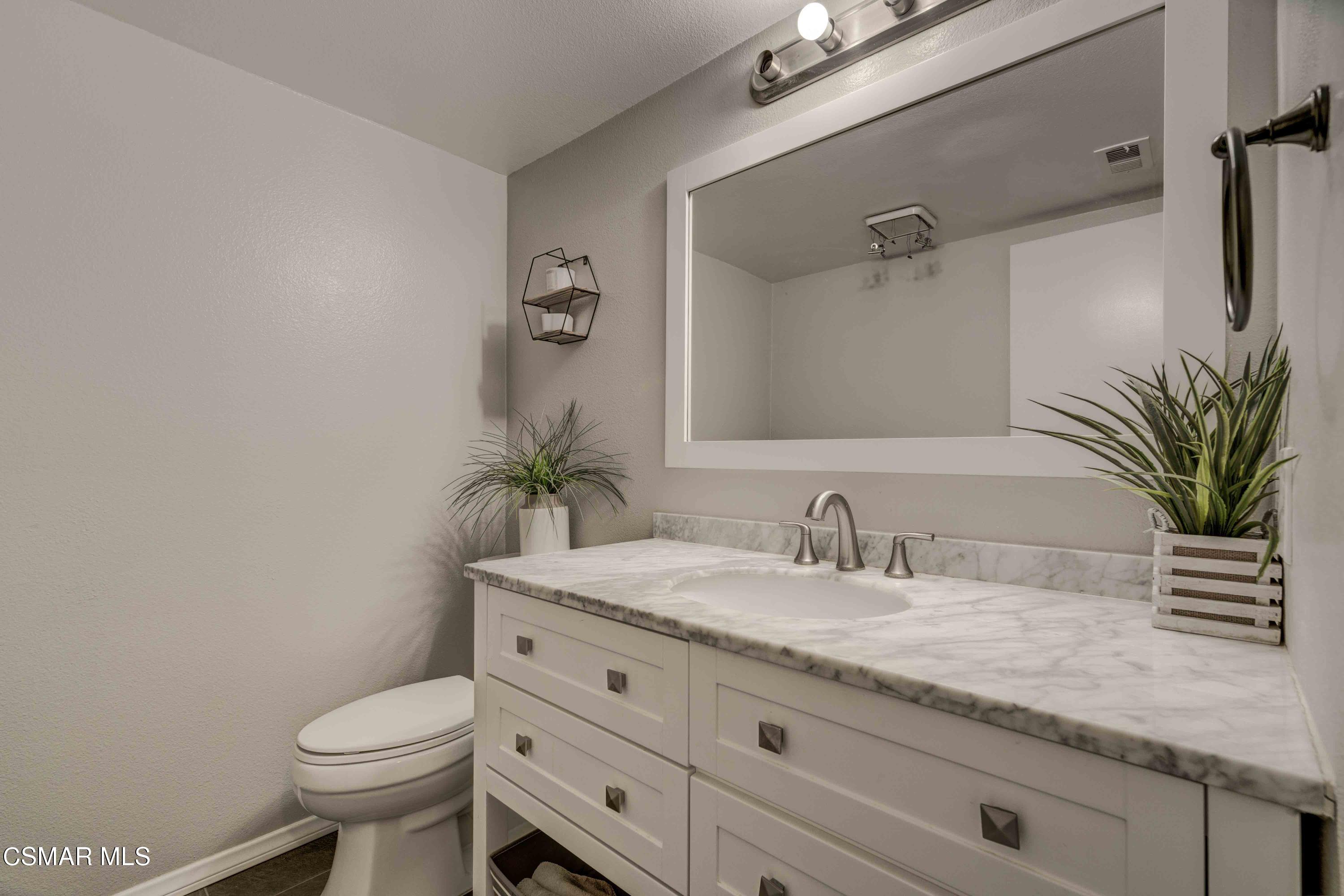 3620 Olds Road Oxnard, CA 93033 - Photo 23 of 34 a bathroom with a granite countertop sink a toilet and a mirror