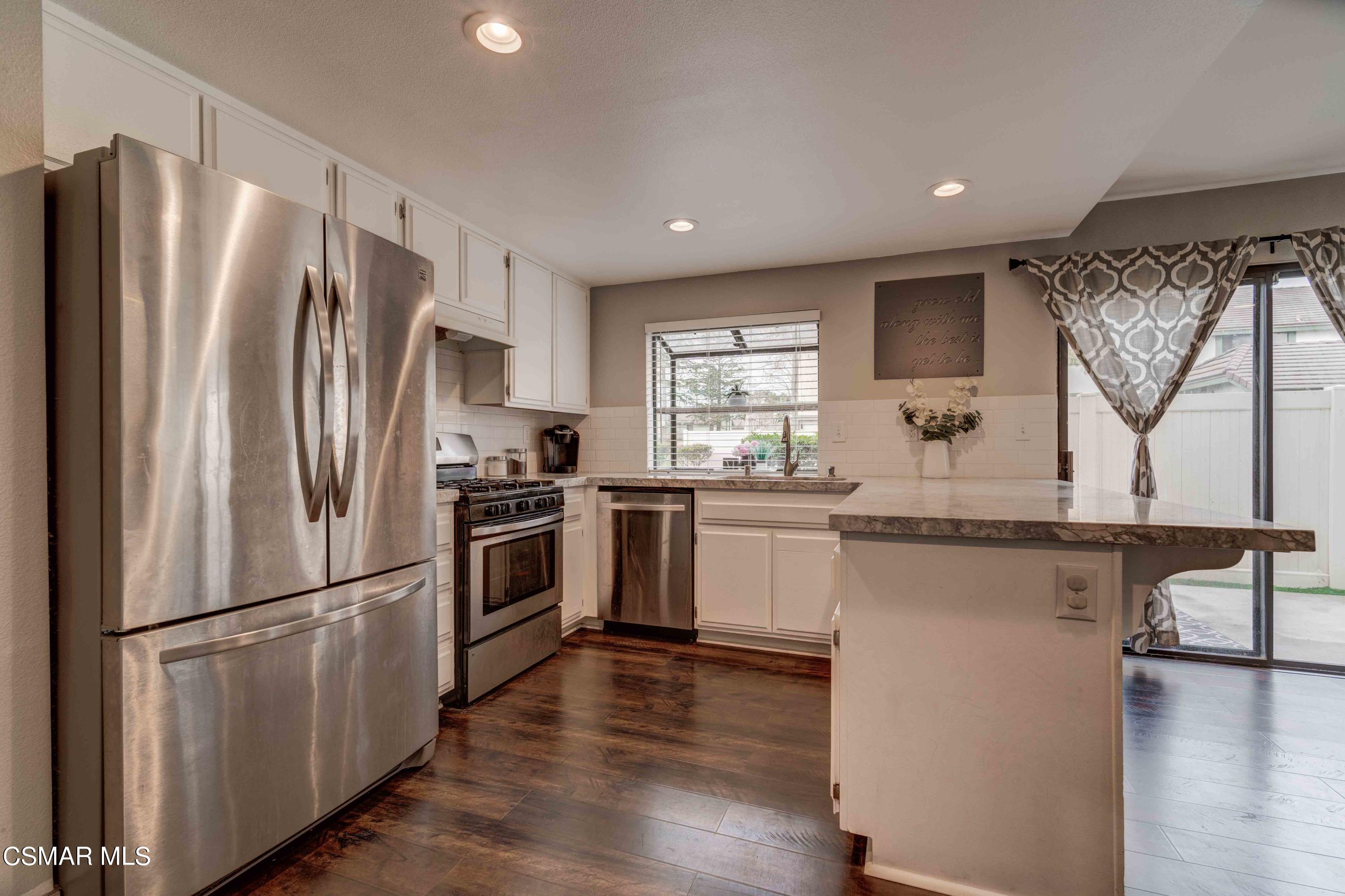 3620 Olds Road Oxnard, CA 93033 - Photo 5 of 34 a kitchen with a refrigerator stainless steel appliances wooden floor and a window