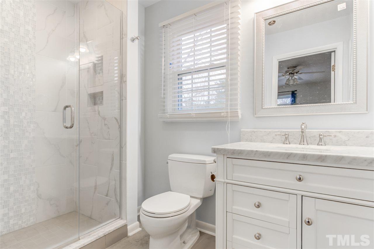 5705 Calorie Court Raleigh, NC 27612 - Photo 15 of 24 a bathroom with a toilet sink vanity and mirror