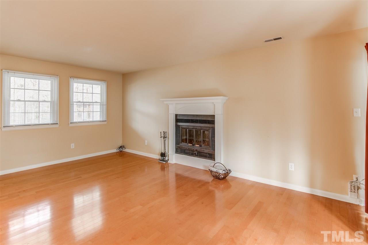 5705 Calorie Court Raleigh, NC 27612 - Photo 5 of 24 an empty room with a fireplace and windows