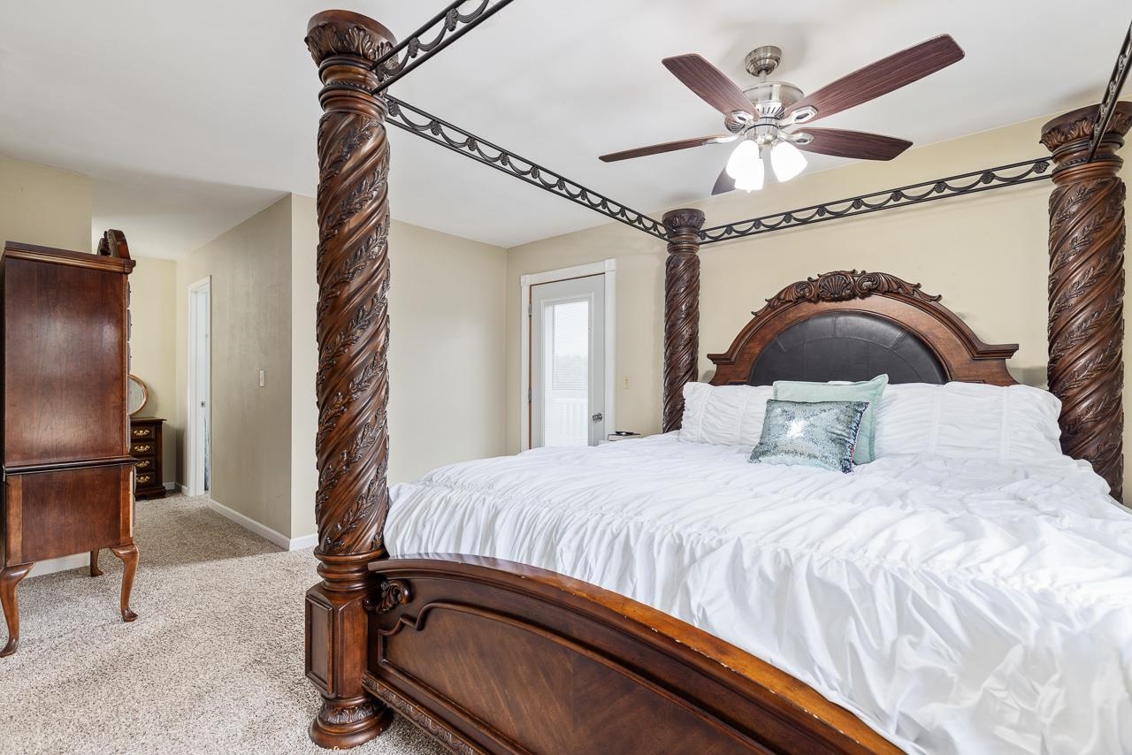 10388 Telegraph Road Winnebago, IL 61088 - Photo 17 of 48 a bedroom with a bed mirror and a ceiling fan