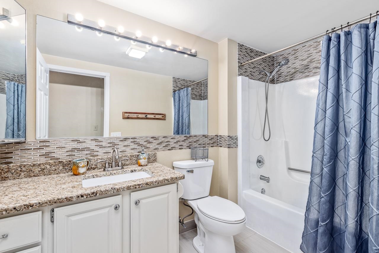 10388 Telegraph Road Winnebago, IL 61088 - Photo 23 of 48 a bathroom with a granite countertop sink a toilet and shower