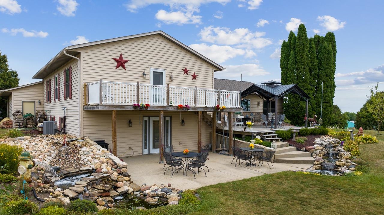 10388 Telegraph Road Winnebago, IL 61088 - Photo 40 of 48 a view of a patio with table and chairs potted plants and a large tree