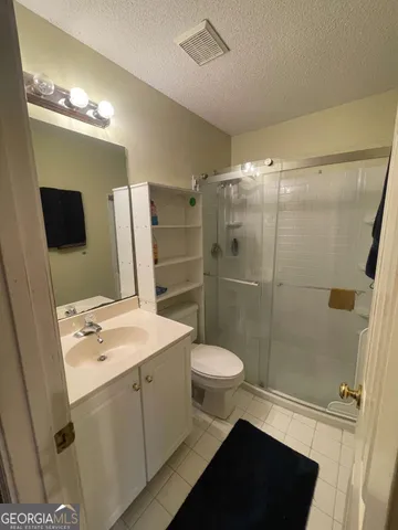 a bathroom with a sink a toilet a mirror and shower
