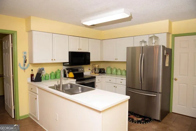 a kitchen with a refrigerator a microwave a sink and cabinets