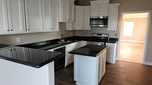 a kitchen with granite countertop a sink and a stove