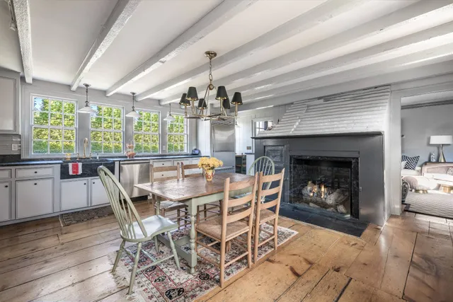 a dining room with furniture a fireplace and wooden floor
