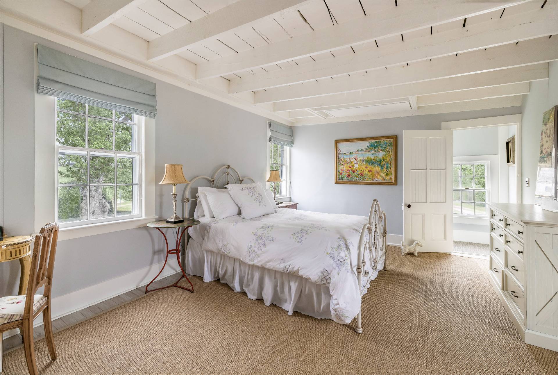 330 Main Street Sag Harbor, NY 11963 - Photo 23 of 32 a spacious bedroom with a bed a table and chair