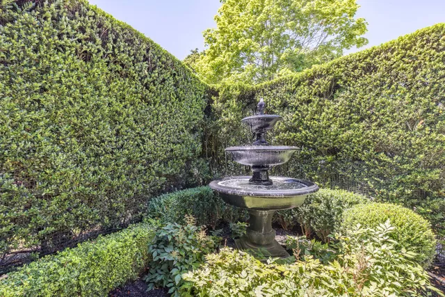 a view of a fountain in the backyard of a house