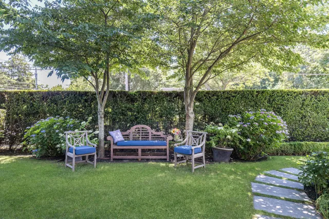 a view of a chair and table in backyard of the house