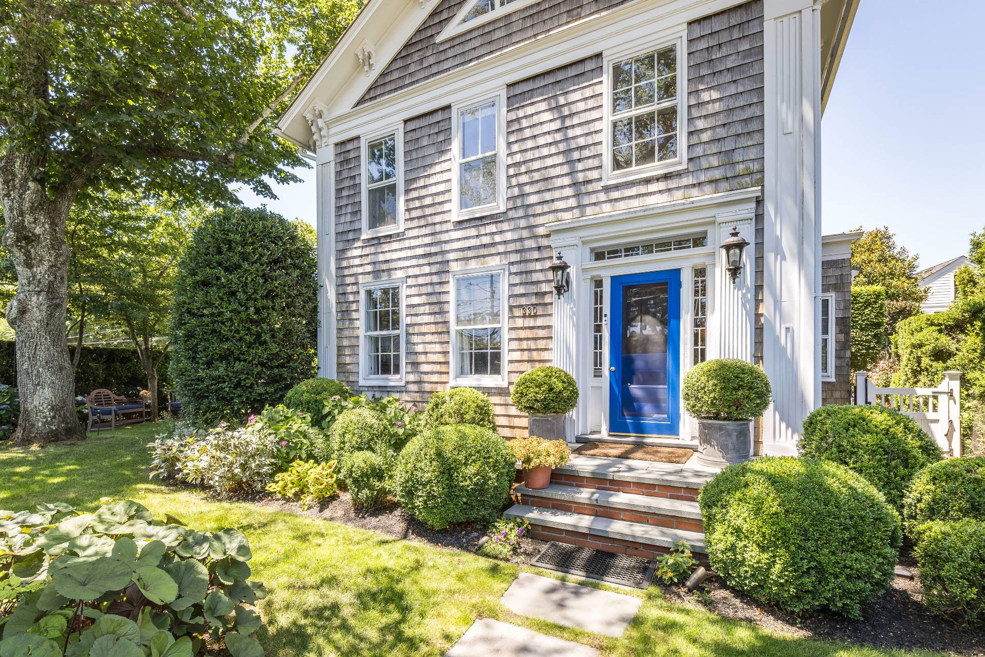 330 Main Street Sag Harbor, NY 11963 - Photo 7 of 32 a view of a house with potted plants and a bench in front of it