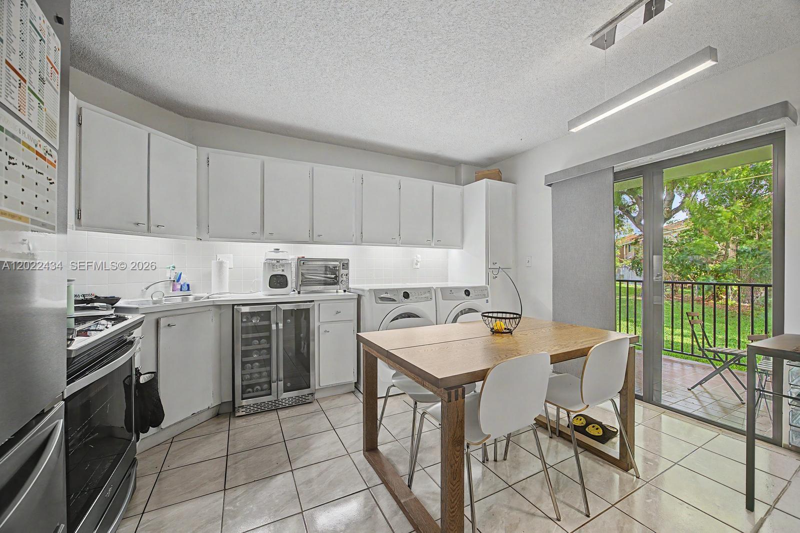 13045 Southwest 68th Street, Unit 111 Miami, FL 33183 - Photo 6 of 15 a kitchen that has a sink a stove top oven a counter space and cabinets