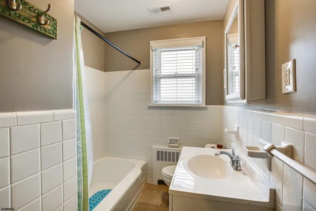 a bathroom with a sink vanity tub and a mirror