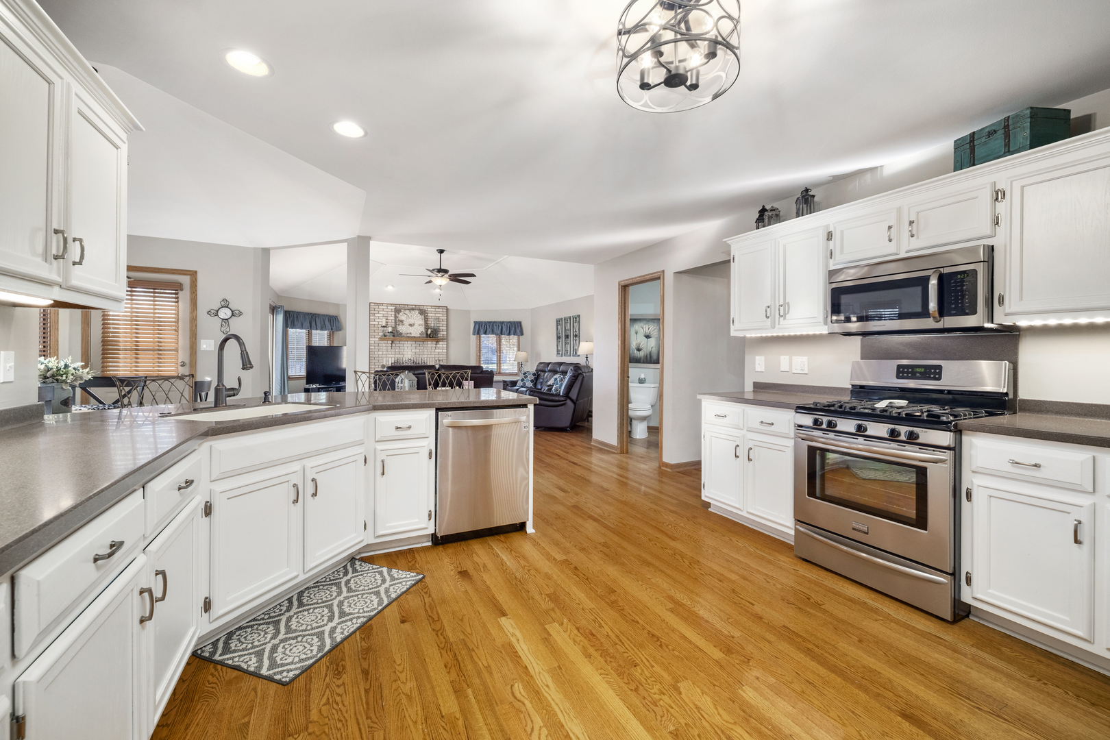 21181 Deerpath Road Frankfort, IL 60423 - Photo 11 of 25 a large white kitchen with stainless steel appliances granite countertop a stove a sink dishwasher and white cabinets with wooden floor