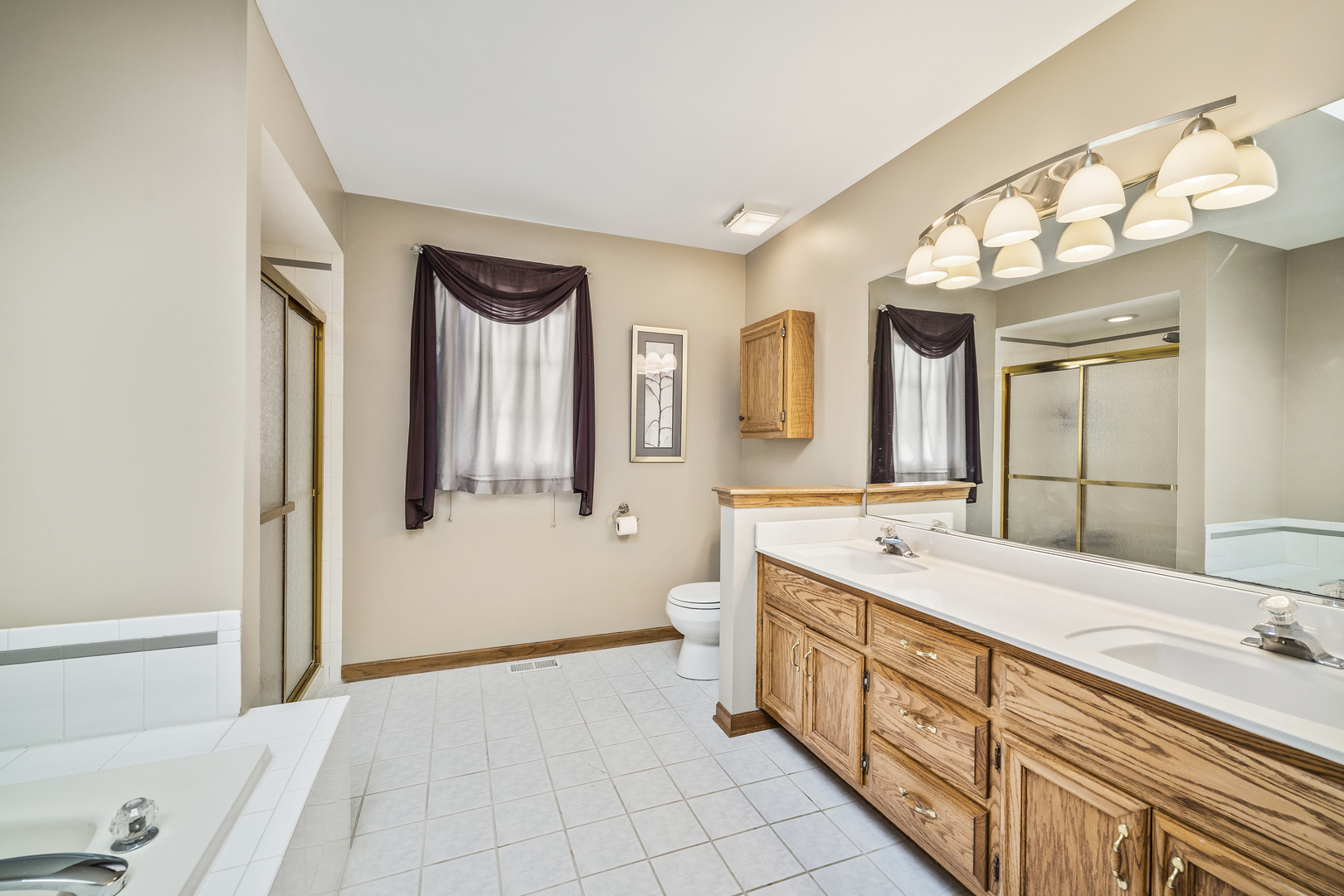 21181 Deerpath Road Frankfort, IL 60423 - Photo 18 of 25 a spacious bathroom with a double vanity sink a mirror a bathtub and a window