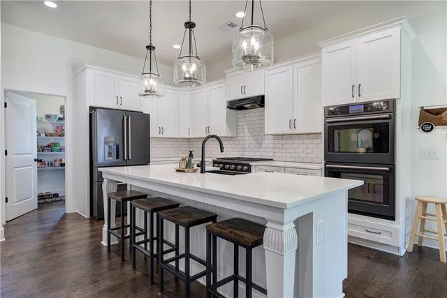 a view of a hallway with wooden floor and a living room