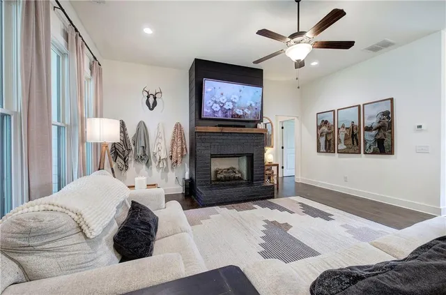 a kitchen with stainless steel appliances granite countertop a stove a refrigerator a kitchen island a dining table and chairs with wooden floor