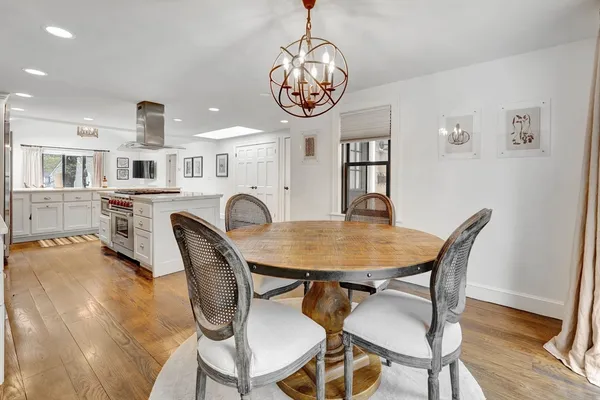 a living room with furniture kitchen view and a large window