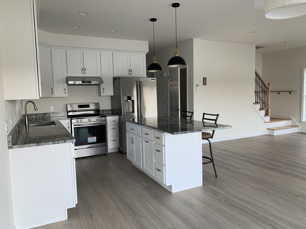 38 Stevens Park Road Charlton, MA 01507 - Photo 9 of 40 a kitchen with stainless steel appliances a stove a sink a refrigerator and wooden floor