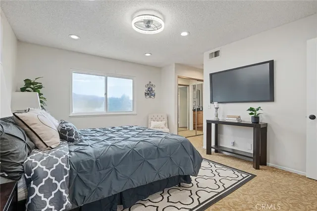 a bedroom with a bed and a flat screen tv