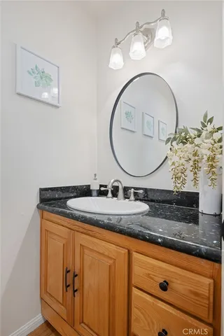 a bathroom with a granite countertop sink a mirror and vanity