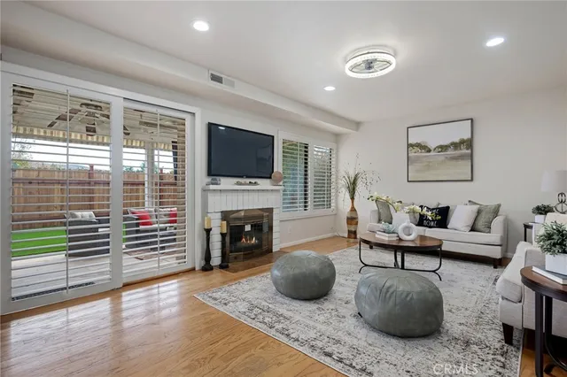 a living room with furniture a flat screen tv and a fireplace