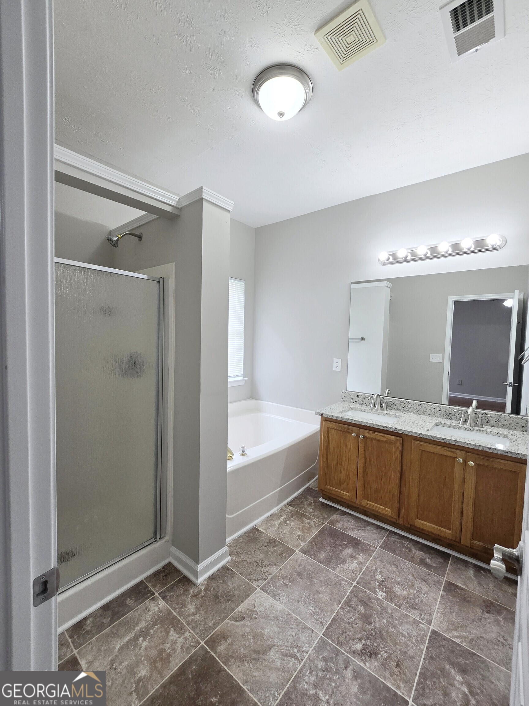 537 Goldfinch Way Stockbridge, GA 30281 - Photo 14 of 20 a bathroom with a tub a double vanity sink and mirror