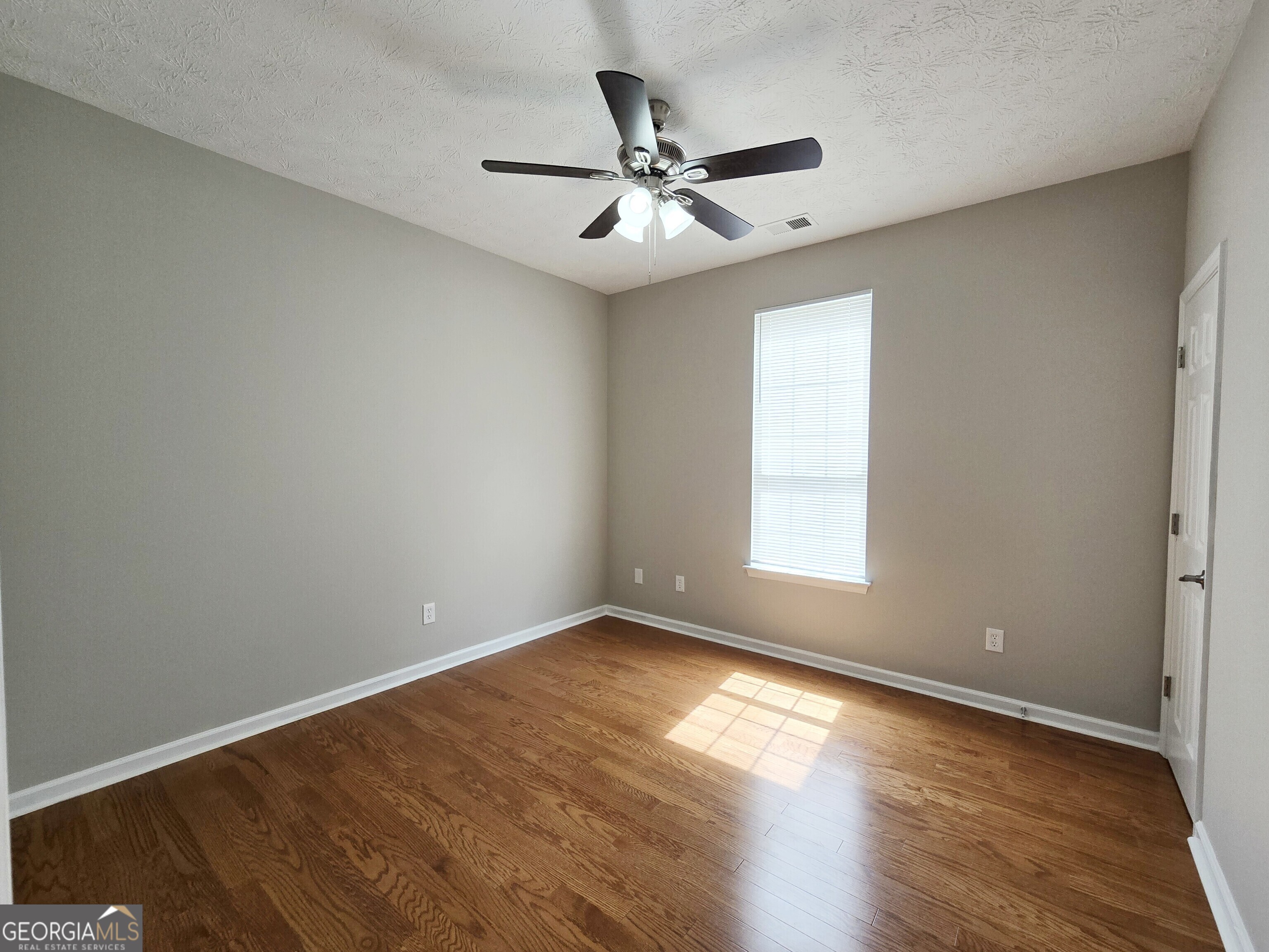 537 Goldfinch Way Stockbridge, GA 30281 - Photo 9 of 20 an empty room with wooden floor fan and windows