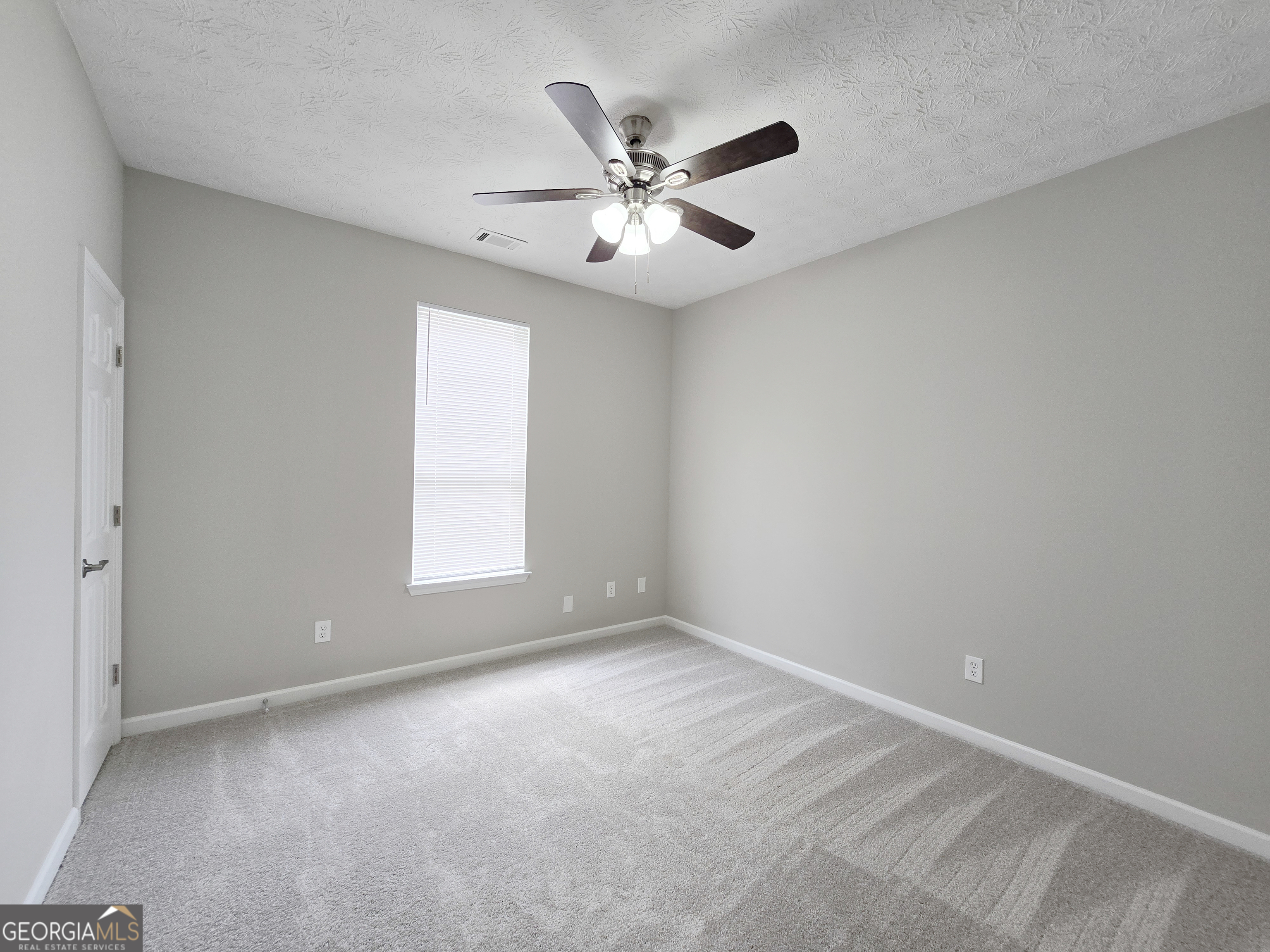 537 Goldfinch Way Stockbridge, GA 30281 - Photo 10 of 20 an empty room with windows and fan