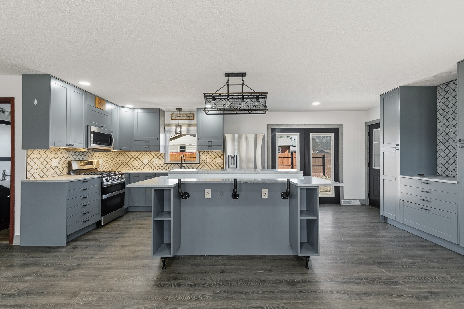 11622 27th Street West Milan, IL 61264 - Photo 5 of 49 a large kitchen with stainless steel appliances a large counter top and wooden floors