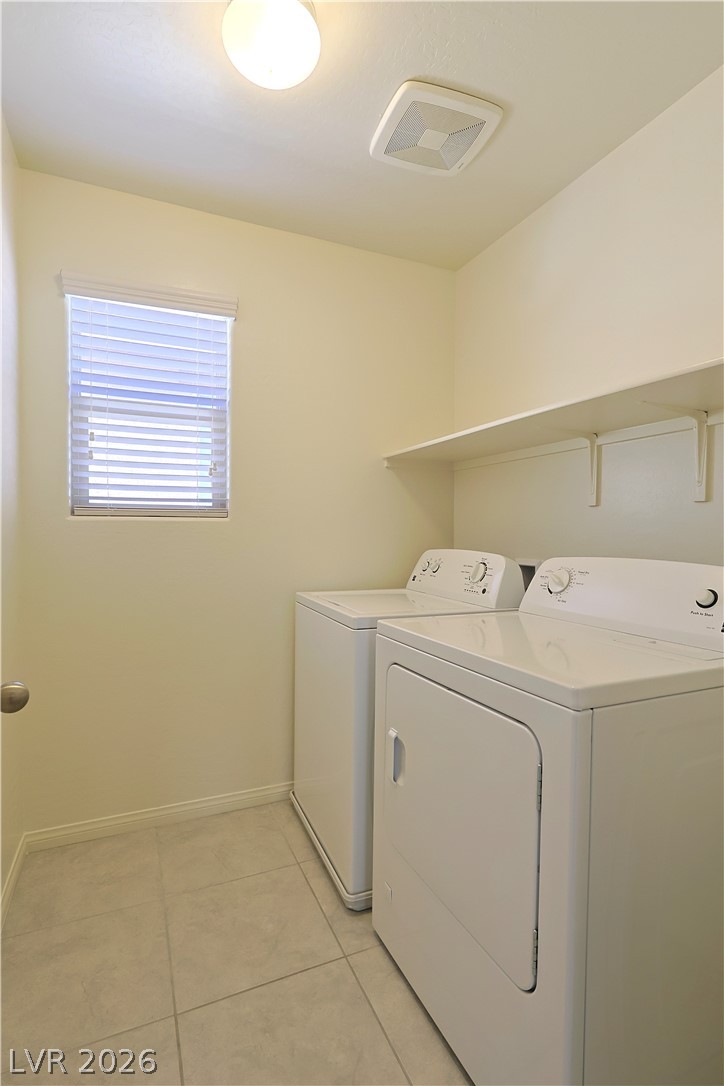8663 Reynolds Spring Street Las Vegas, NV 89178 - Photo 30 of 32 Tiled flooring and a built-in overhead shelf frame this functional utility space.
