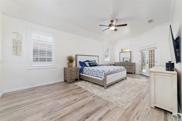 a spacious bedroom with a bed and a flat screen tv