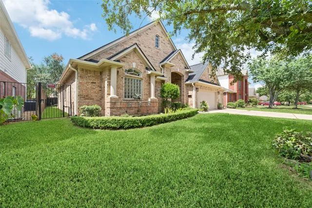 a front view of a house with a yard and trees