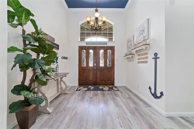 a view of a hallway with wooden floor and a chandelier