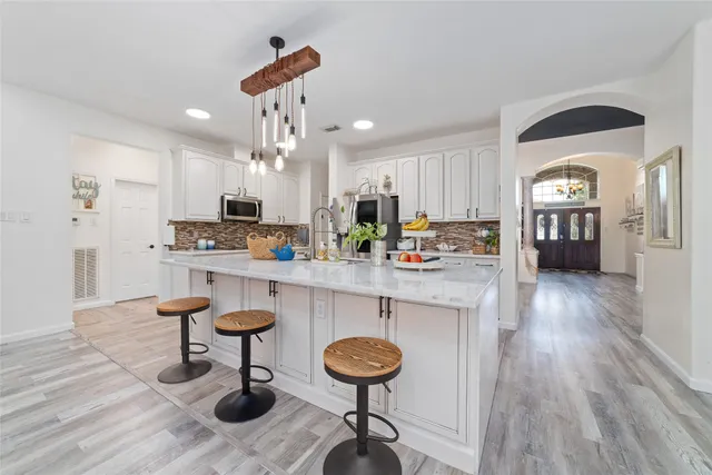 a kitchen with stainless steel appliances kitchen island granite countertop a stove a sink and a refrigerator