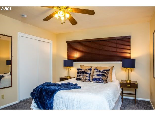 8325 Southwest Terwilliger Boulevard Portland, OR 97219 - Photo 19 of 30 a bedroom with a bed and a chandelier