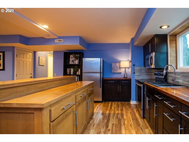 8325 Southwest Terwilliger Boulevard Portland, OR 97219 - Photo 24 of 30 a kitchen with stainless steel appliances granite countertop a sink and cabinets