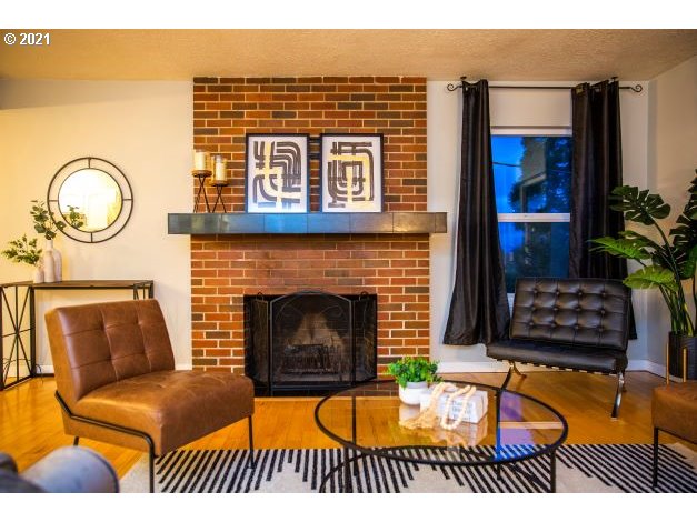 8325 Southwest Terwilliger Boulevard Portland, OR 97219 - Photo 6 of 30 a living room with furniture a rug and a fireplace