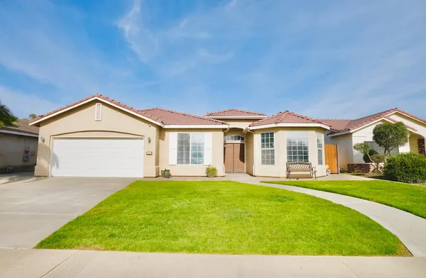 a view of a house with a yard and pathway