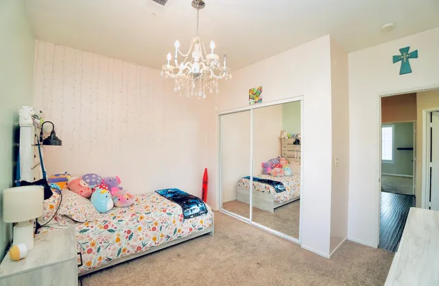 a bedroom with bed and a chandelier