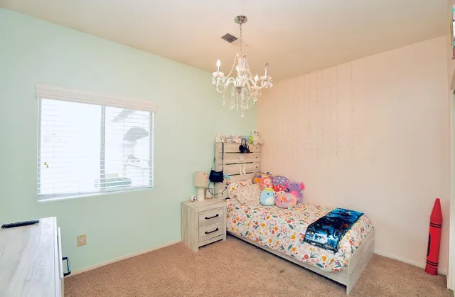 a bedroom with a bed and a chandelier