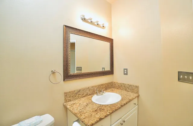 a bathroom with a granite countertop sink and a mirror