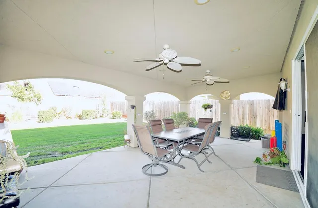 a living room with patio furniture and a chandelier